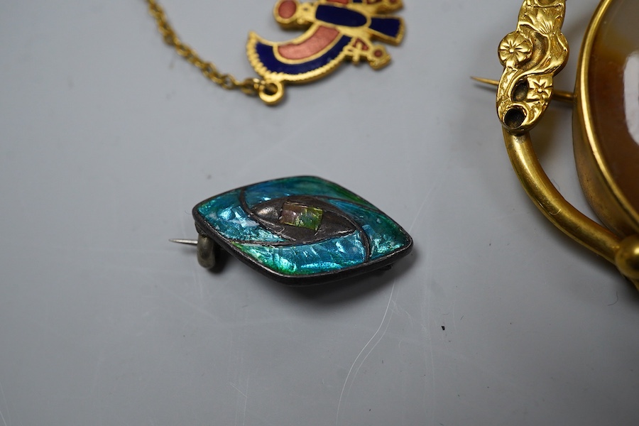 A group of gilt metal / pinchbeck jewels and an Arts & Crafts brooch by William Hair Haseler, comprising: a hinged bangle; an enamelled pendant in the Egyptian revival style; a gold curb link bracelet with a heart-shaped